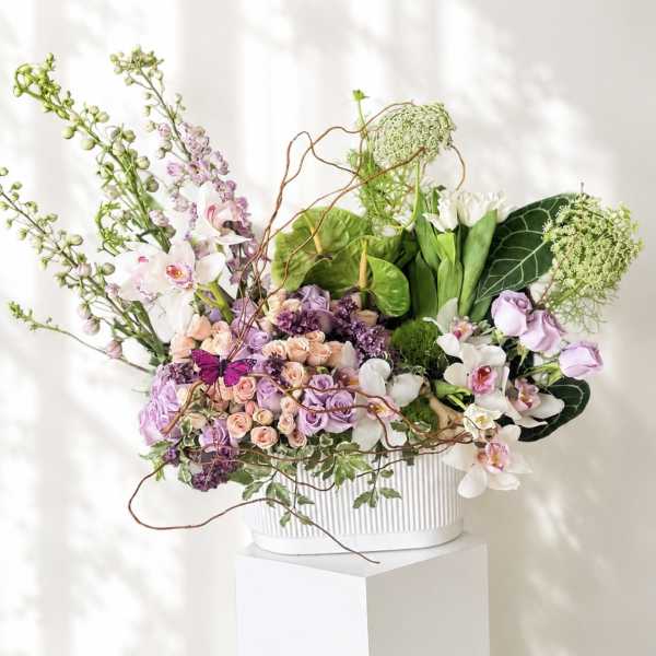 Mixed pastel floral arrangement in a white ribbed container