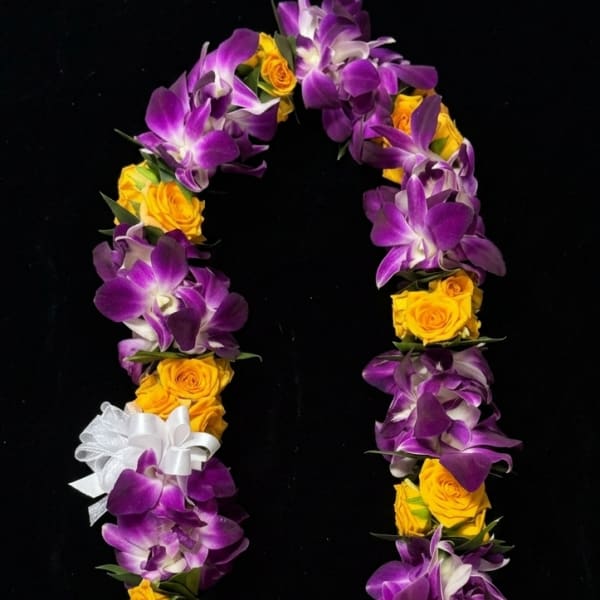 Purple orchid and yellow rose lei on a black background