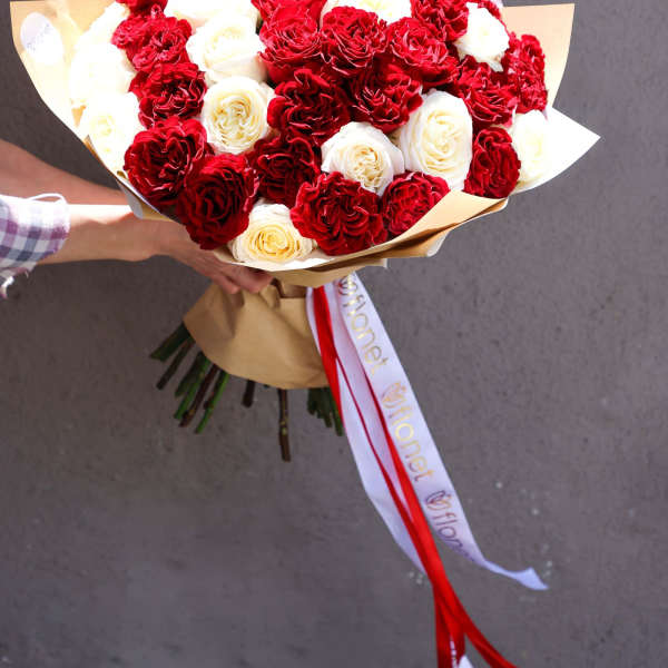 Bouquet of red and white roses wrapped in brown paper