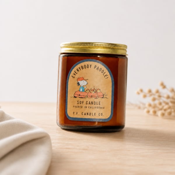 Soy candle in a glass jar with a gold lid and illustrated label