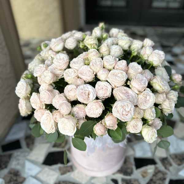 Bouquet of pale pink spray roses in a light pink vase