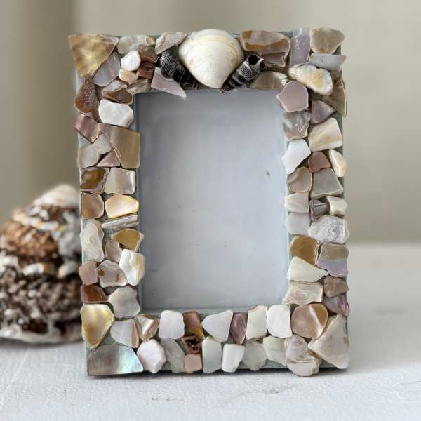 Decorative photo frame covered in shell pieces