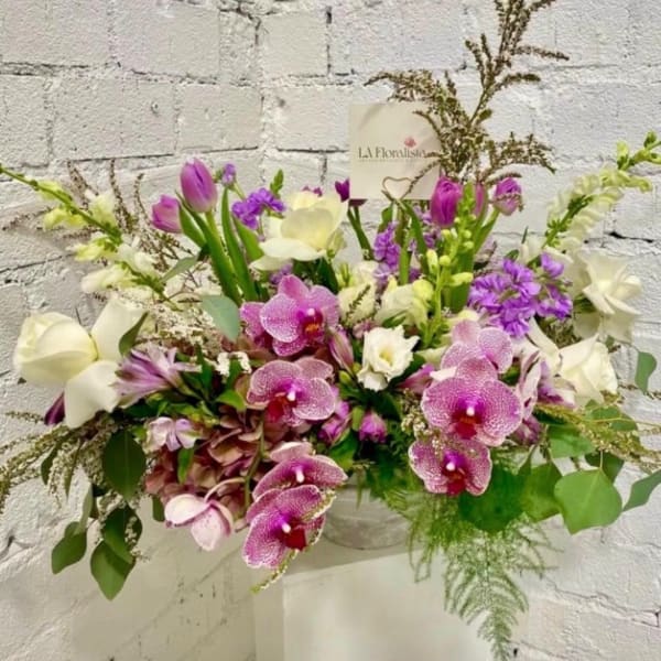 Purple and white mixed flower arrangement in a vase