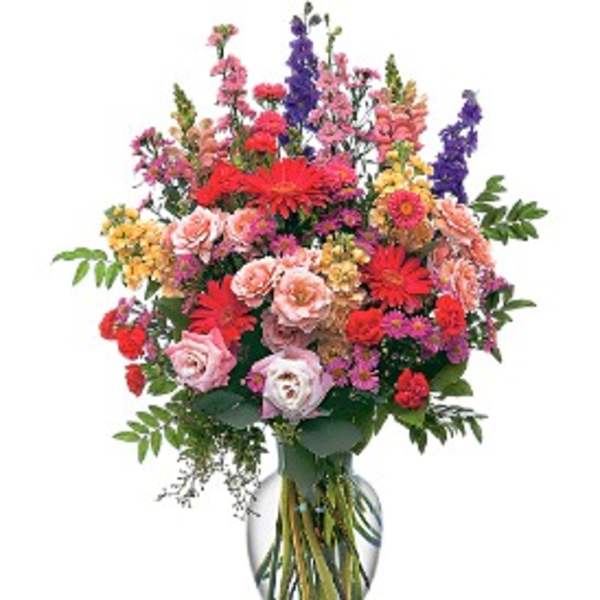 Mixed bouquet of colorful flowers in a clear glass vase