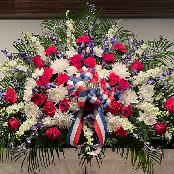 Large red, white, and purple floral spray with a patriotic ribbon