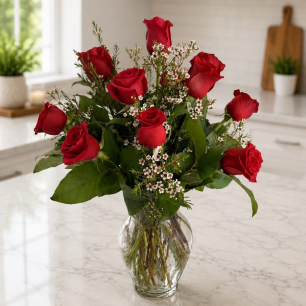 Red roses arranged in a clear glass vase
