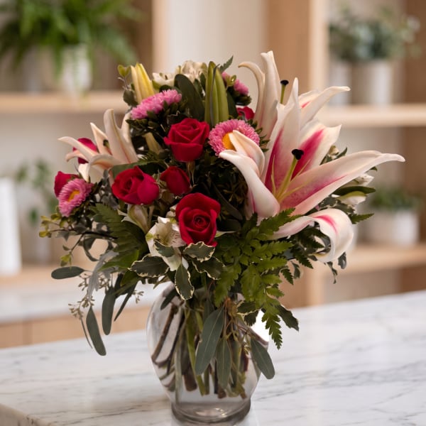 Bouquet of pink roses and white lilies in a glass vase