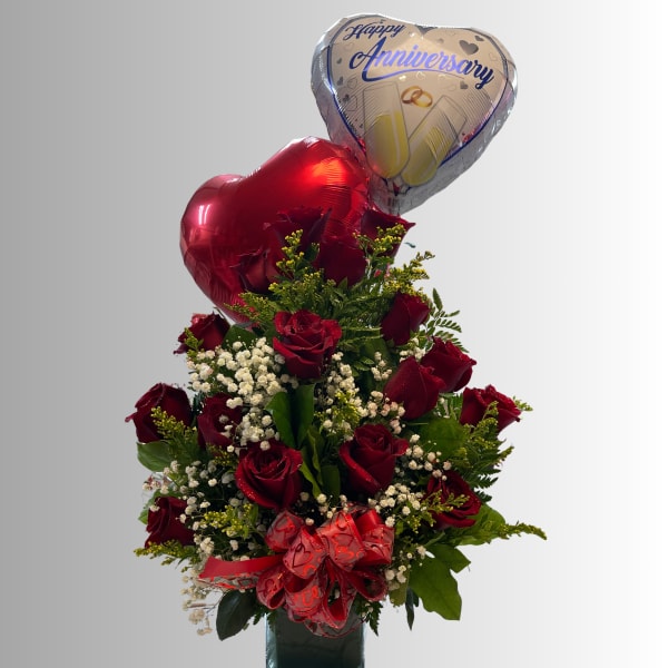 Red rose arrangement with anniversary heart balloons in a vase