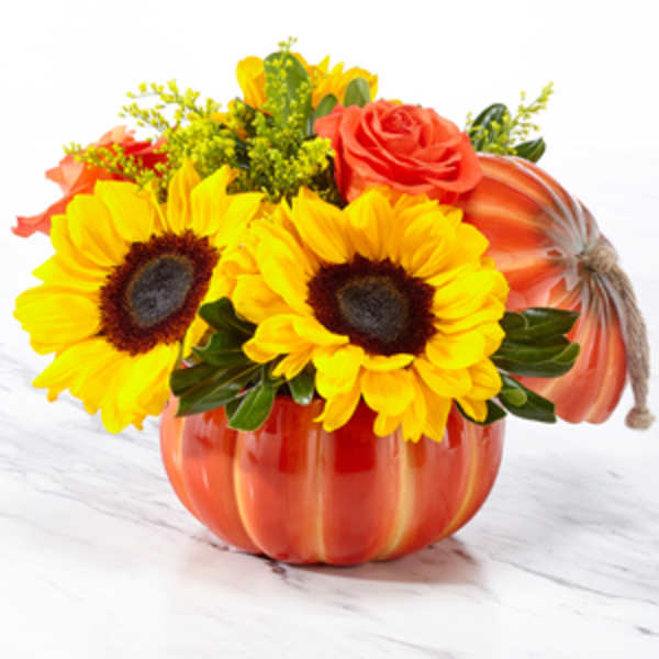 Sunflowers and roses arranged in a pumpkin-shaped container