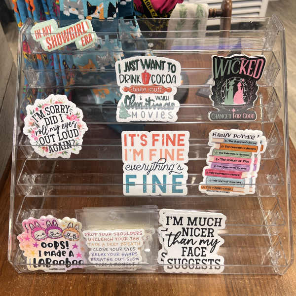 Clear acrylic display rack holding assorted decorative stickers and decals