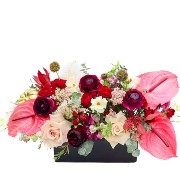 Mixed floral arrangement in a black rectangular container with pink anthuriums and roses