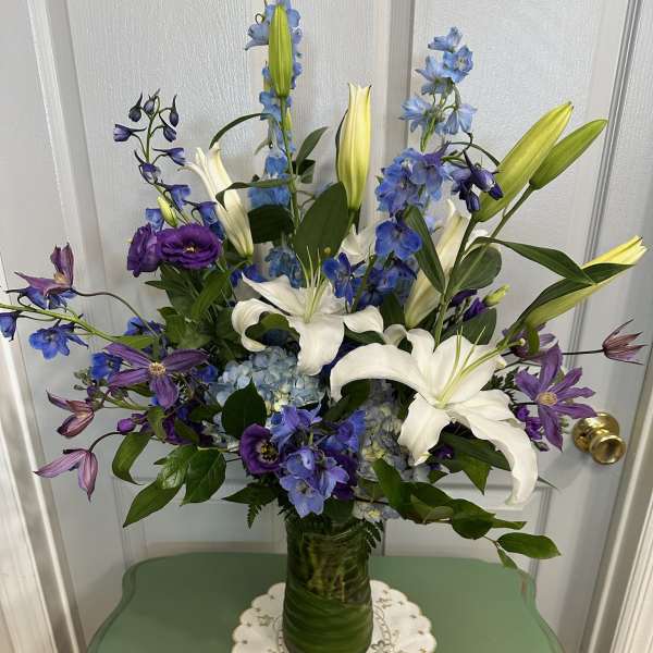 Blue and white floral arrangement in a glass vase