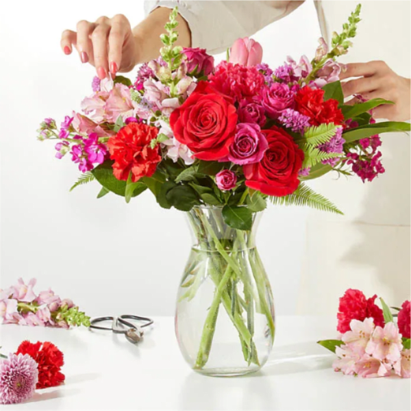 Bouquet of red and pink flowers in a clear glass vase