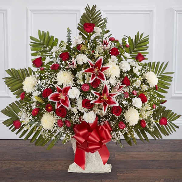 Large red and white floral spray with palm fronds and a red ribbon