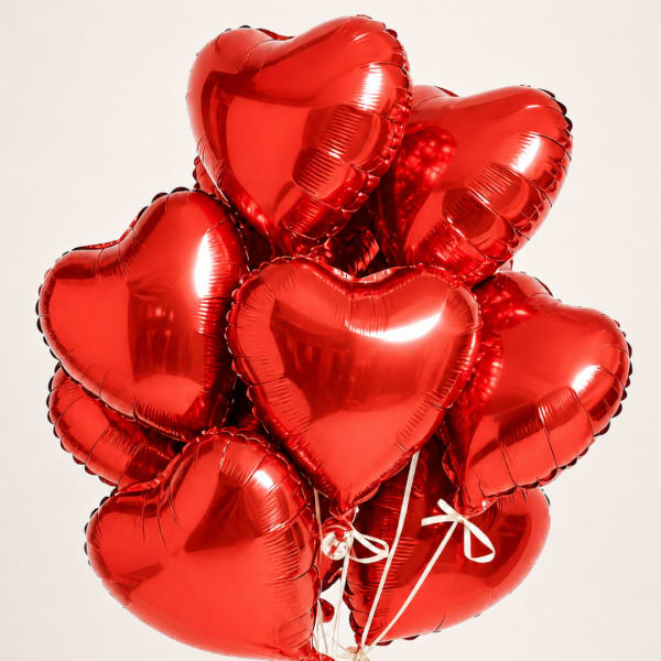 Cluster of red heart-shaped balloons tied with white ribbons
