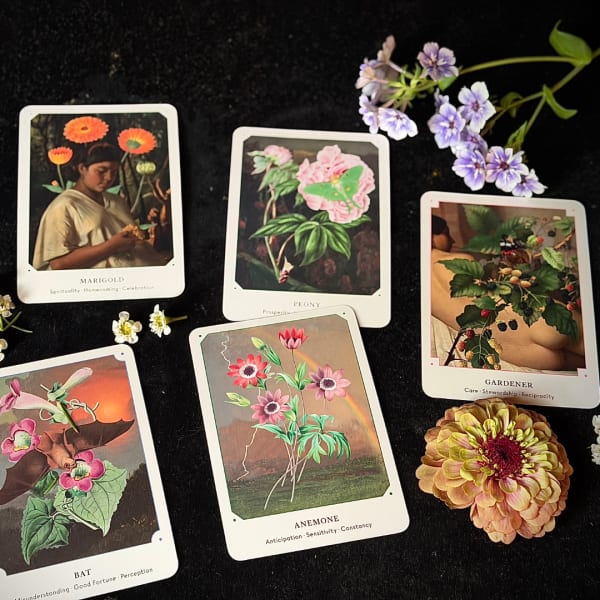 Flower-themed cards and small blossoms arranged on a dark surface
