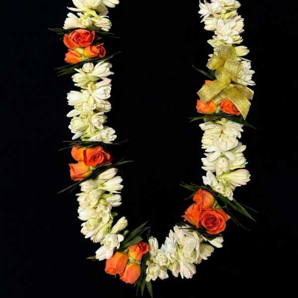 Orange roses and white flowers arranged in a floral garland