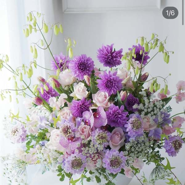 Lavender and pink floral arrangement in a white bowl vase