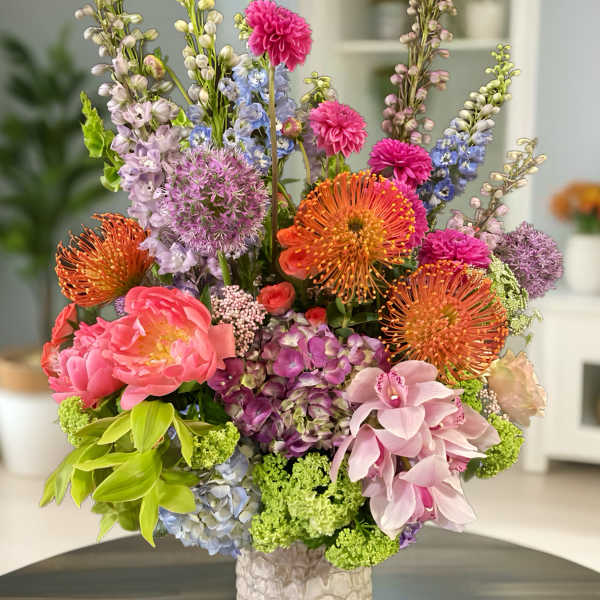 Colorful mixed flower arrangement in a textured white vase