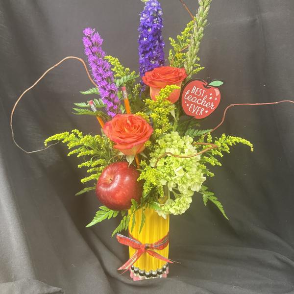 Mixed floral arrangement with roses, hydrangea, and an apple in a yellow vase