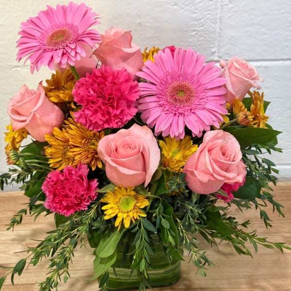 Pink roses, gerbera daisies, and carnations in a glass vase