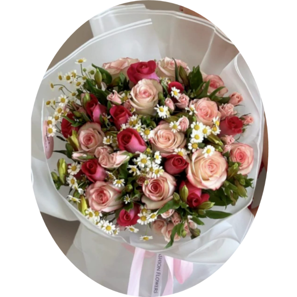Bouquet of pink and red roses with small white daisies wrapped in white paper