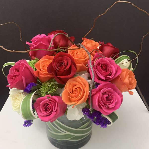 Mixed roses in a glass vase with curly branches
