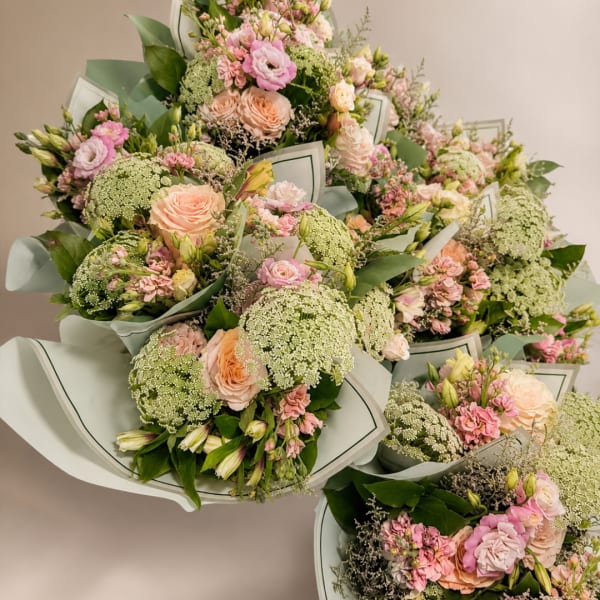 Bouquets of pink and peach roses with green filler flowers