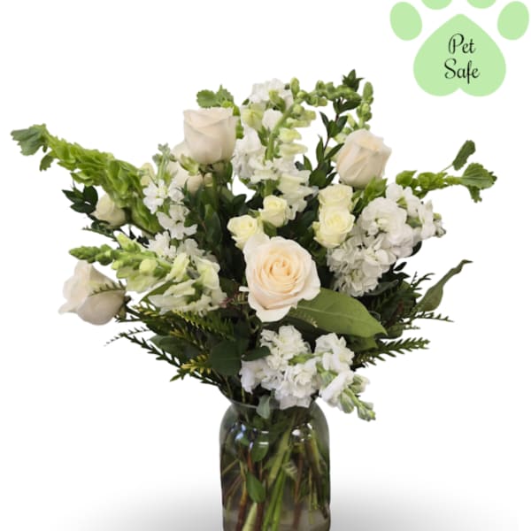 White roses and mixed white flowers in a glass vase