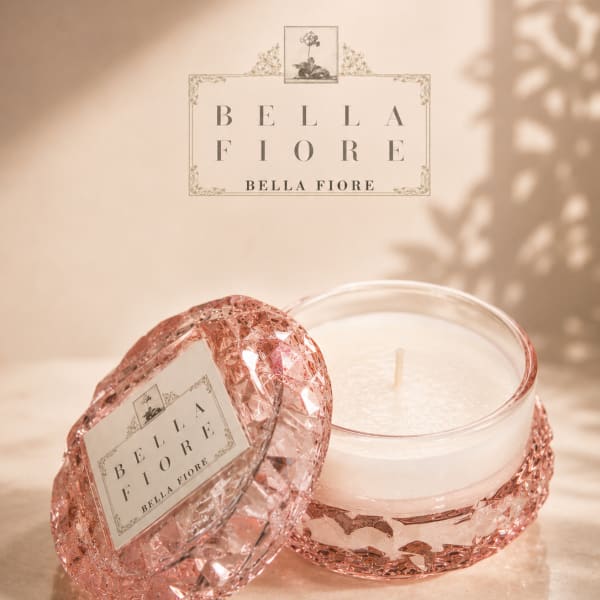 Pink glass candle jar with a white candle and matching lid