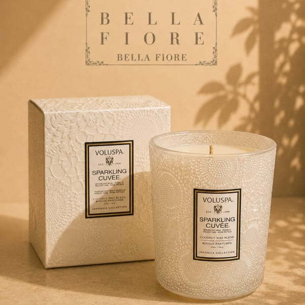 Two decorative scented candles in textured glass containers with a matching box