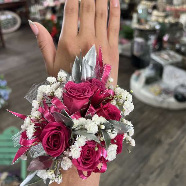Pink rose wrist corsage with white filler flowers and silver ribbon