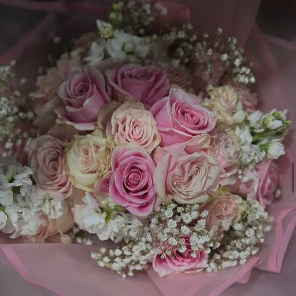 Pink and cream rose bouquet wrapped in pink paper