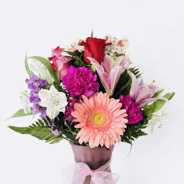Mixed bouquet in a pink vase with a ribbon bow