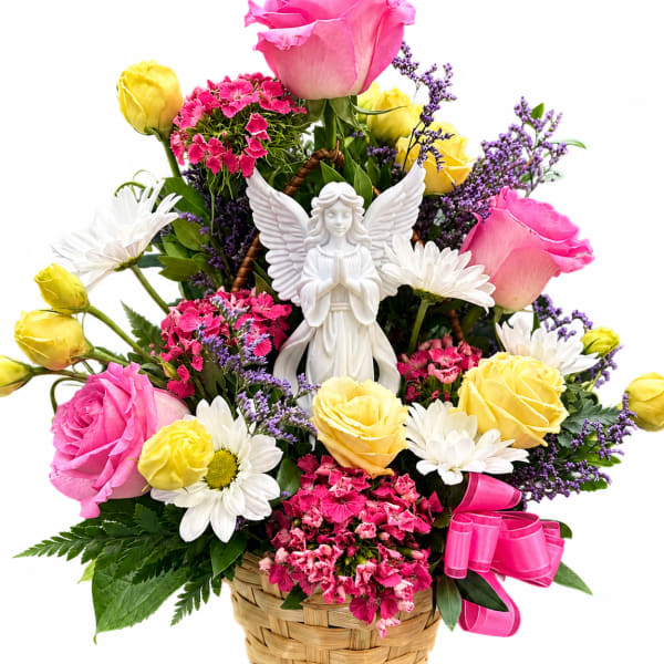 Basket arrangement of pink and yellow roses with daisies and an angel figurine