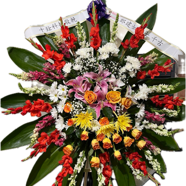 Large standing floral tribute with red, white, yellow, and pink flowers