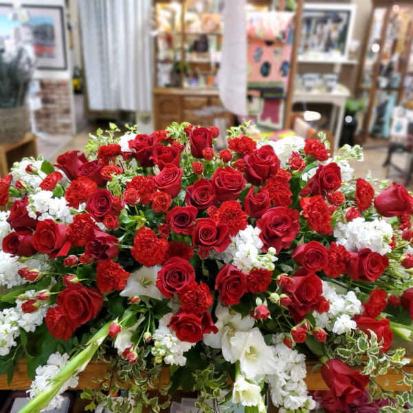 Large arrangement of red roses and white flowers on a table