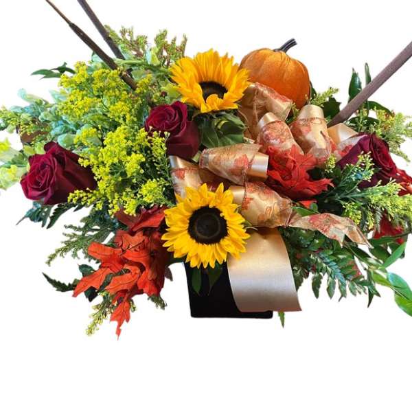 Autumn bouquet with sunflowers, red roses, and a pumpkin in a black vase