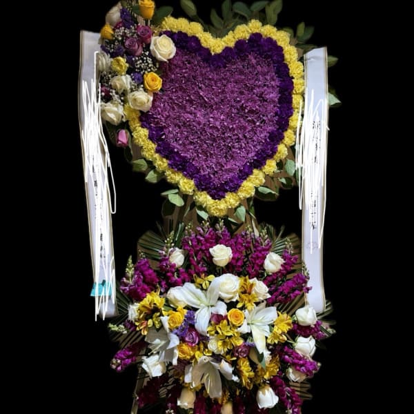 Heart-shaped purple and yellow floral arrangement with a mixed bouquet below