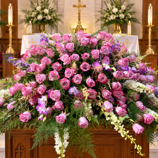 Large pink rose arrangement on a church altar with white flowers