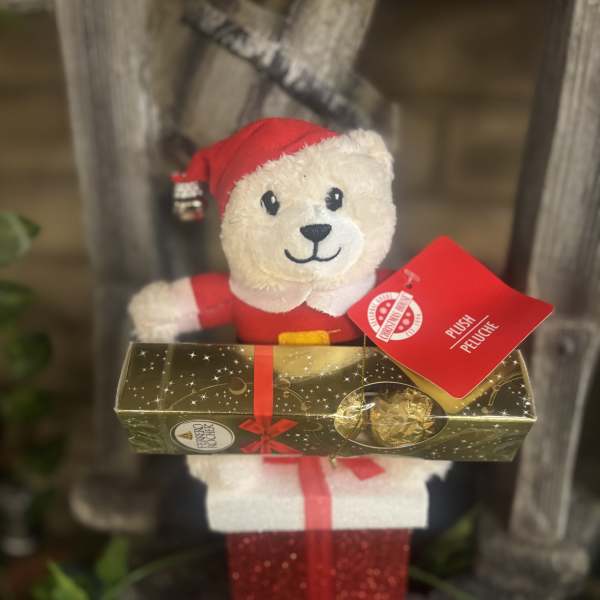 Plush teddy bear holding a box of chocolates and a gift box