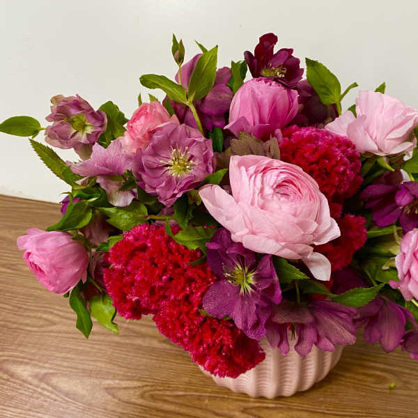 Pink and purple flower arrangement in a white vase