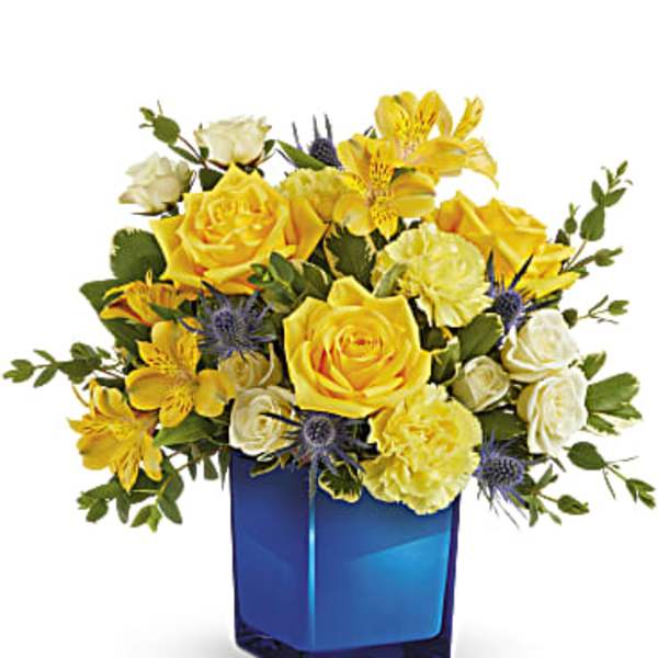 Yellow and white roses with yellow alstroemeria in a blue glass vase