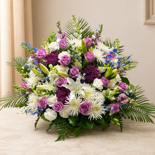Lavender roses and white lilies in a low, full arrangement