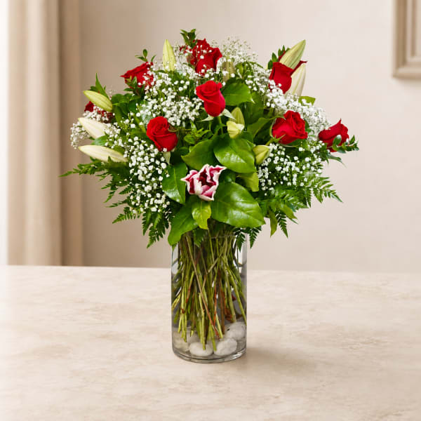 Red roses and white lilies in a clear glass vase