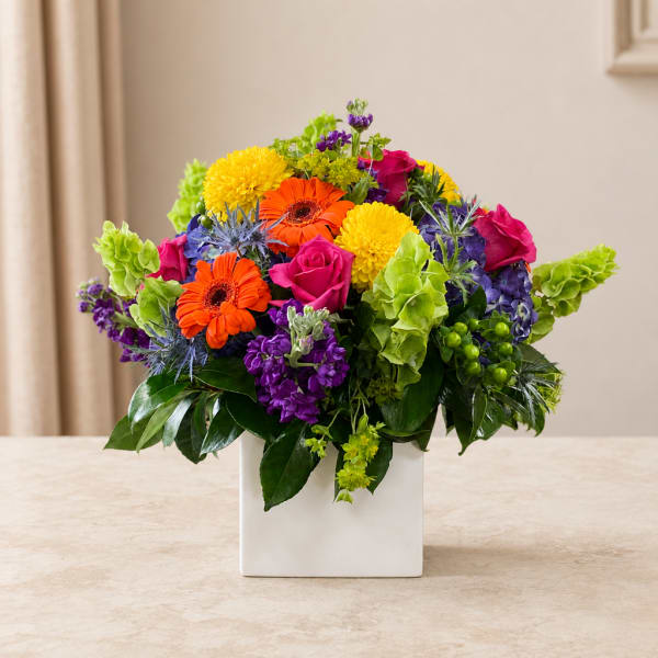 Colorful mixed bouquet in a white square vase