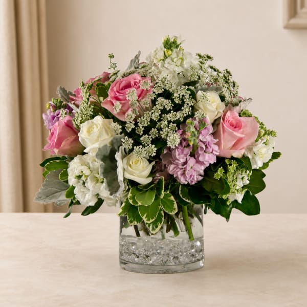 Pink and white rose bouquet in a clear glass vase