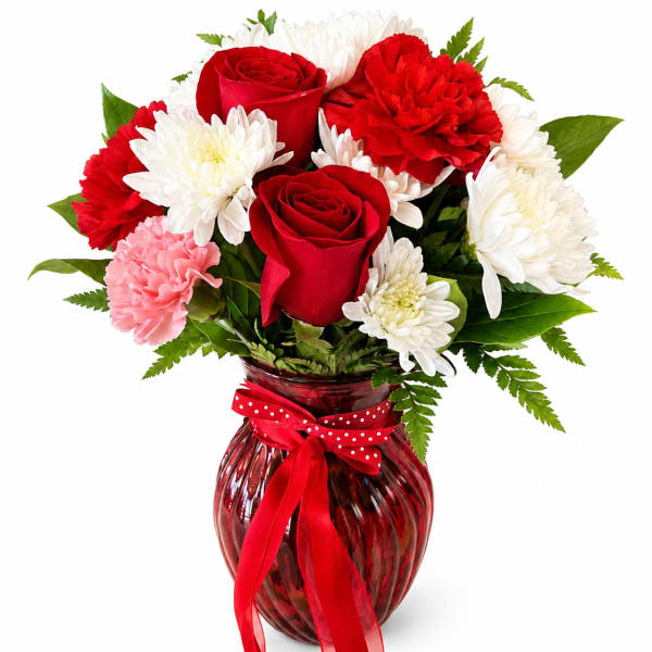 Red roses and white chrysanthemums in a red glass vase with a ribbon