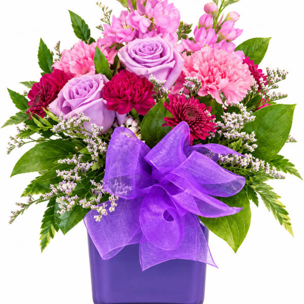 Pink and lavender mixed bouquet in a purple vase with a purple ribbon