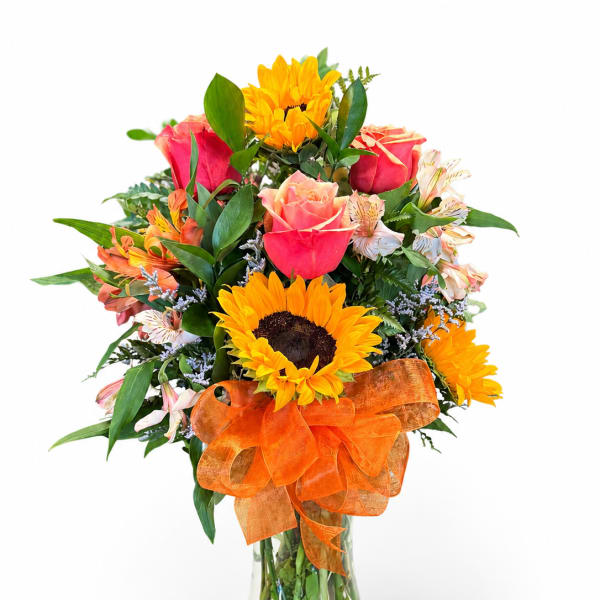 Mixed bouquet with sunflowers, roses, and alstroemeria in a glass vase